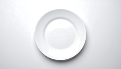 Overhead shot of a plain, white circular dish on a white background. The plate is centered, displaying a clean and minimalist design