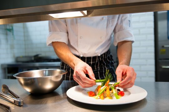 Chef plating a gourmet dish with fresh vegetables and vibrant colors