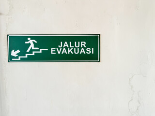 Obraz premium Evacuation Route Sign on Building Wall