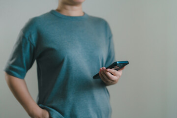 One hand holding mobile phone in casual clothes. Symbolizes modern digital life, device usage, internet connection, and lifestyle simplicity with mobile technology.