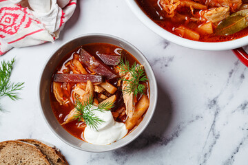 Classic homemade borscht with chicken in a grey bowl.
