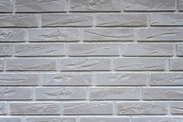Stone wall with much gray bricks of the modern building.