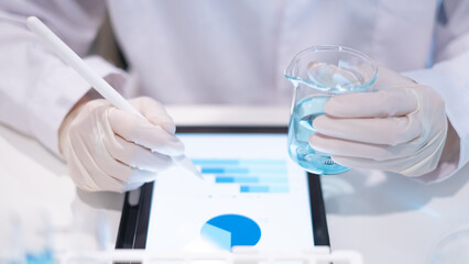 Scientist holding test tube beaker laboratory results report on tablet for data analysis online study science research technology biology chemistry medical discovery experiment innovation development