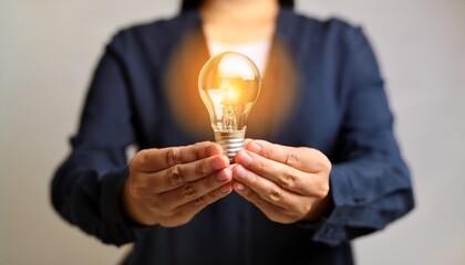 hands holding glowing light bulb symbol inspiration and creative ideas concept copy space innovation and motivation brainstorming design thinking knowledge sharing and positive energy