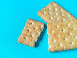 golden colored broken biscuits on bright blue background