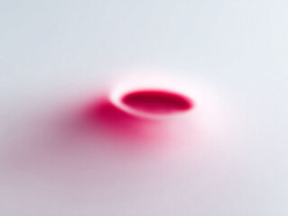 Abstract image of a splash or drop of red liquid on a soft grey background. Use it for themes of purity, minimalism, or hidden depths. Perfect for medical, food, or creative projects.