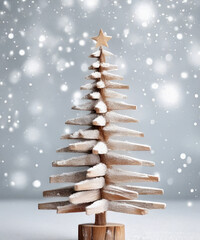 A rustic wooden Christmas tree stands elegantly against a frosty silver background, evoking a cozy holiday spirit.