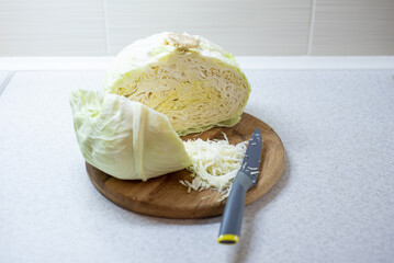 Close-up of white cabbage on a wooden board with a knife, shredder for sourdough.