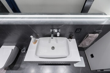 Luxury bathroom interior, black marble walls and grey floor.