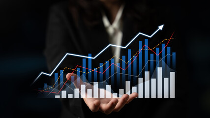 A business professional showcases an advanced digital display of financial graphs and charts,...