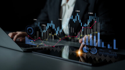 Business professional reviews financial data displayed on a laptop and tablet, highlighting trends...