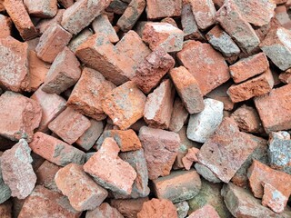 A pile of shattered, disorganized red bricks. Used construction materials for backgrounds, textures, or the concept of destruction or renovation.