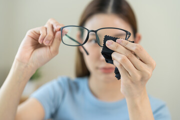 Cleaning glasses concept, close up hand of asian young woman hand holding frame of glass, use cloth...