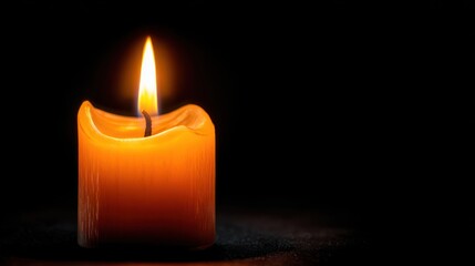 Lit candle against a dark background flame and wax close up
