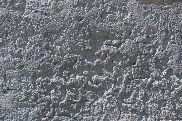 Rough textured concrete surface with cracks and shadows
