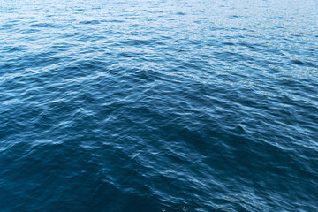 Calm blue ocean water with gentle ripples and sunlight reflections