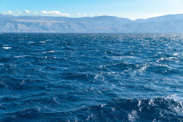 Obraz premium Vast blue ocean with distant mountain views on a clear day