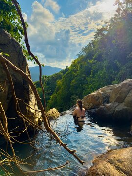 Young Woman Enjoys Sunset View in Natural Jungle Infinity Pool
