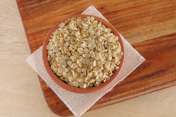 Gluten-free millet Jowar (Sorghum) flakes in wooden bowl,Close up