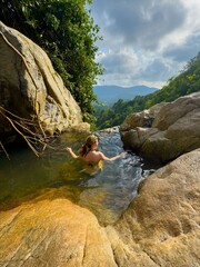 Woman Admires Breathtaking Jungle Mountain View from Natural Pool