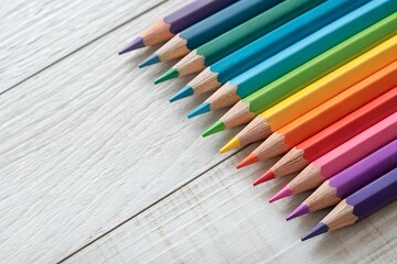Obraz premium colored pencils arranged on a white background and wooden table