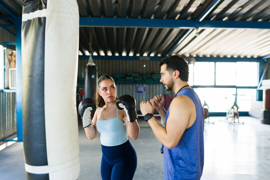 Woman training boxing with personal coach in gym