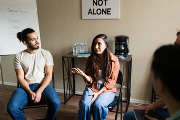 Sad woman sharing experiences in mental health support group