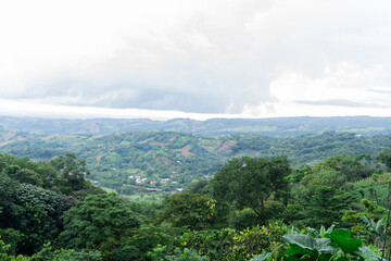 Central American natural landscape photograph taken on a semi-cloudy day from the mountain height with small birds in the distance