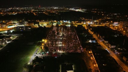 Aerial view of a Polish cemetery on All Saints’ Night, glowing with thousands of candles that...