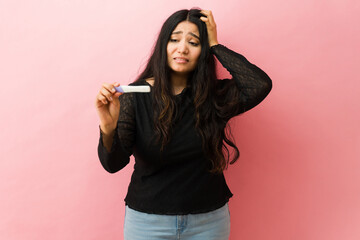 Woman feeling stressed after receiving pregnancy test result