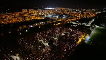 Aerial view of a Polish cemetery on All Saints’ Night, glowing with thousands of candles that...