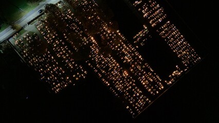 Aerial view of a Polish cemetery on All Saints’ Night, glowing with thousands of candles that...