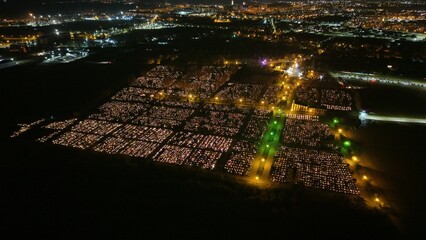 Aerial view of a Polish cemetery on All Saints’ Night, glowing with thousands of candles that...