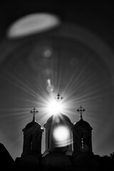 Black and White Silhouette of Church Domes with Dramatic Sunburst and Lens Flare