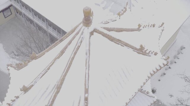 Aerial view of snowy Chinese temple roof, D-Log footage