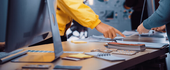 A vibrant workspace showcases professionals engaged in collaborative design activities. Colorful samples and materials are spread across a stylish table, highlighting creativity. SACTR