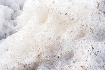 Detail background of Murky foam piles created by floating fast from flow of polluted water from a large water pump for wastewater treatment.