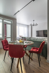 Cozy Dining Area with Red Velvet Chairs and Green Sofa