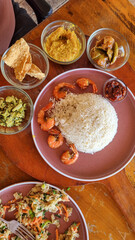 A stunning display of traditional Thai cuisine is spread out on a rustic wooden surface. Colorful plates include green curries, pad Thai, and crispy spring rolls garnished with fresh herbs.