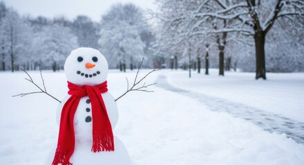 A snowman with a red scarf and carrot nose in a snowy park.