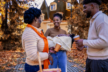 Naklejka premium African American Family Walking to Autumn Picnic with Sleeping Baby