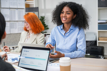 African American businesswoman speaking with team during office meeting, reviewing documents,...
