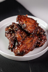 Delicious honey glazed chicken wings with sesame and spices on plate