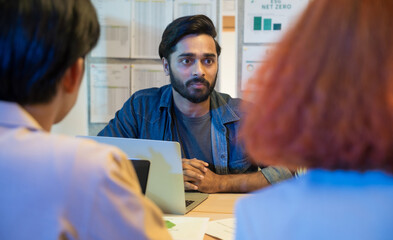 Diverse business team meeting in modern office to discuss sustainability, ESG goals, and eco-friendly strategies focused on green initiatives, environmental responsibility, and corporate ethics.