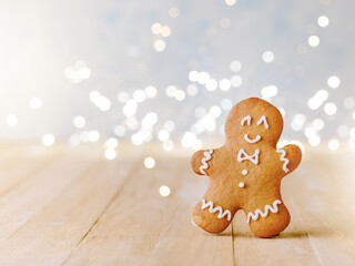Fototapeta premium Christmas gingerbread cookies with Christmas decorations and garland with bokeh on wooden background. Christmas card design element.