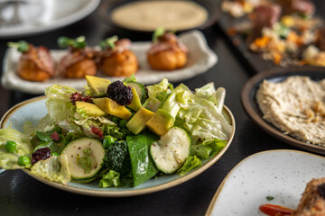 Fresh salad with avocado and other dishes on a table