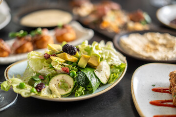 Fresh salad with avocado and blackberries on a plate, close-up shot