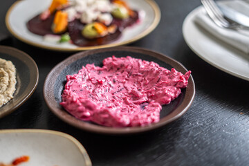 Close-up of a colorful beetroot salad with other dishes on a table