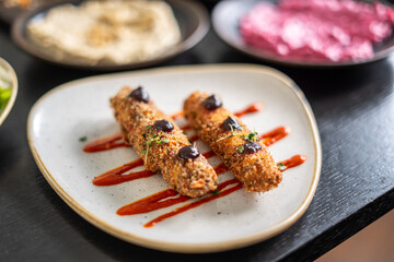 Delicious fried appetizers with sauce on a white plate, ready to eat