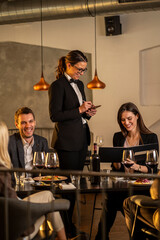 Waitress taking order from customers at a restaurant table